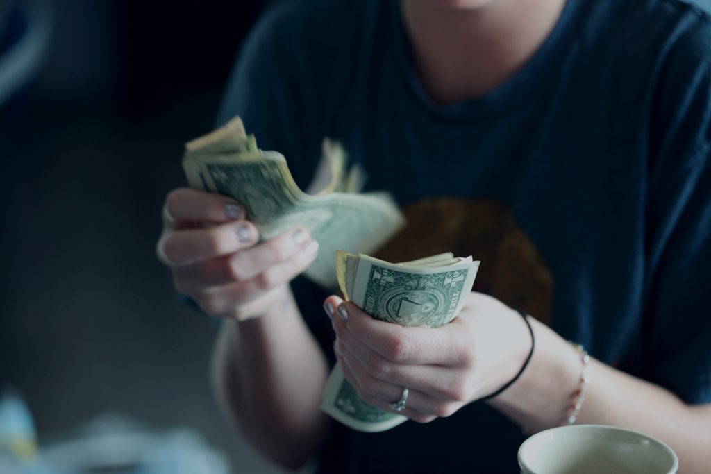 close up of hands and dollar bills